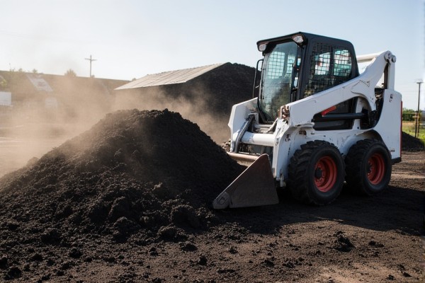 Skid steer bucket attachment in action